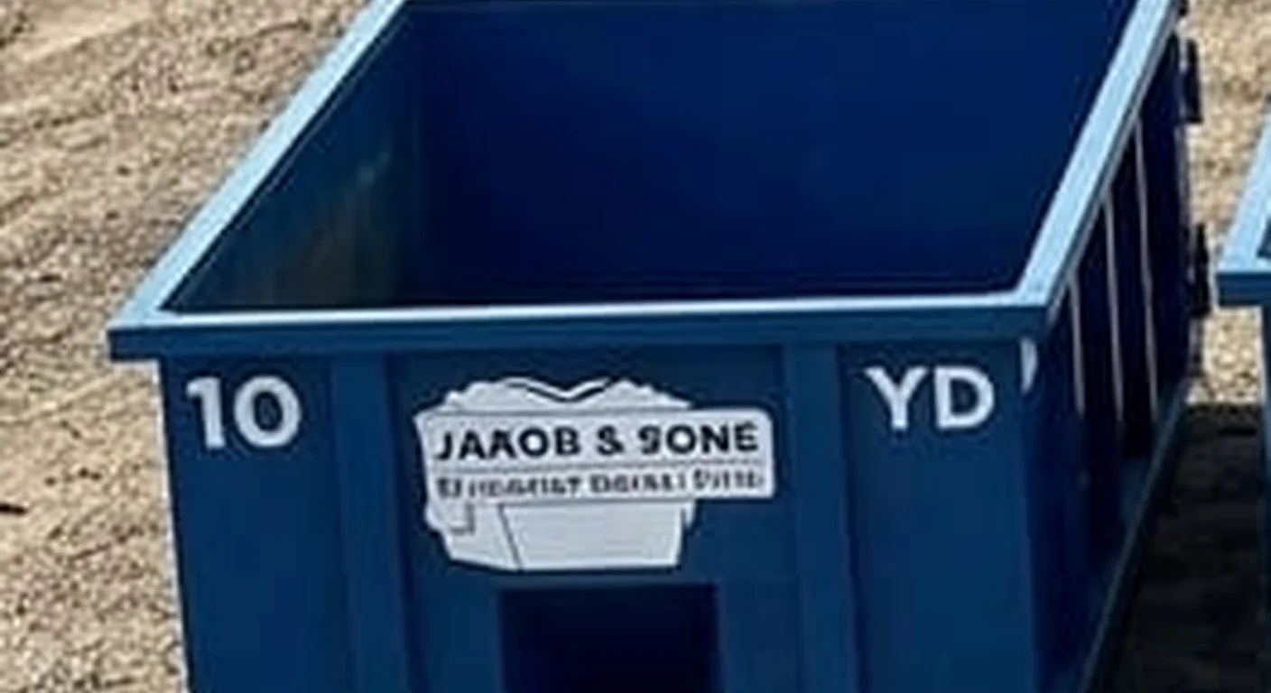 A clean, correctly-labeled 10 yard Jakob & Sons Dumpster Rental roll-off container staged at the company yard