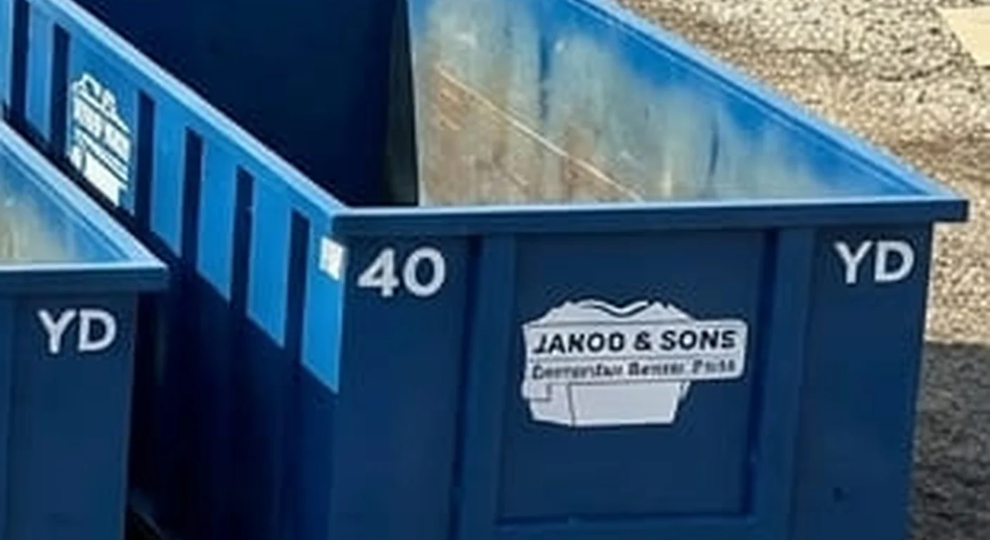 A clean, correctly-labeled 40 yard Jakob & Sons Dumpster Rental roll-off container staged at the company yard